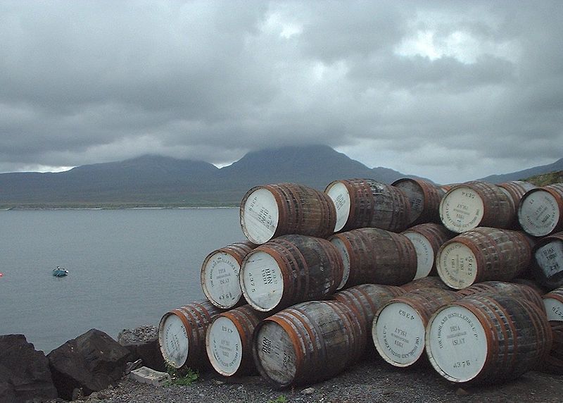 Empty casks outside Bunnahabhain distillery, looking across the Sound of Islay towards the Paps of Jura, shrouded in cloud. Photographed by James Gray, 2001